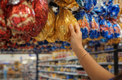 Imagem da notícia Imagem de mão feminina mexendo em ovo de Páscoa afixado com outros em suporte no alto da imagem