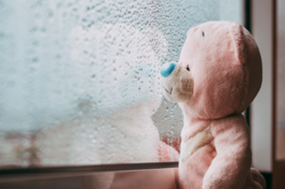 Imagem da notícia Imagem de urso de pelúcia rosa "olhando" através de vidro com respingos de chuva