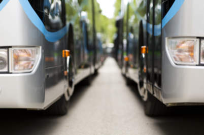 Imagem da notícia Dois ônibus prateados lado a lado vistos de frente, metade de cada frente visível