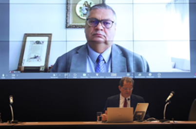 Imagem da notícia Imagem do ministro Flávio Dino no telão do auditório, com presidente do TRT-2, des. Valdir Florindo, sentado à mesa diretiva abaixo do telão