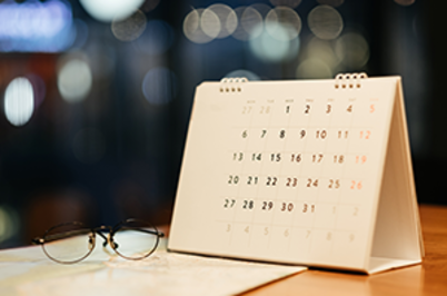 Imagem da notícia Imagem de calendário em papel e óculos sobre a mesa