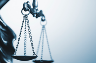 Imagem da notícia Imagem de meia estátua da justiça, com foco na balança ao lado esquerdo, em fundo branco acinzentado