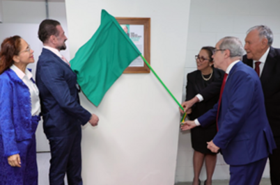 Imagem da notícia Grupo de pessoas em trajes formais participando do descerramento de um quadro em uma parede, puxando o pano verde que o cobre