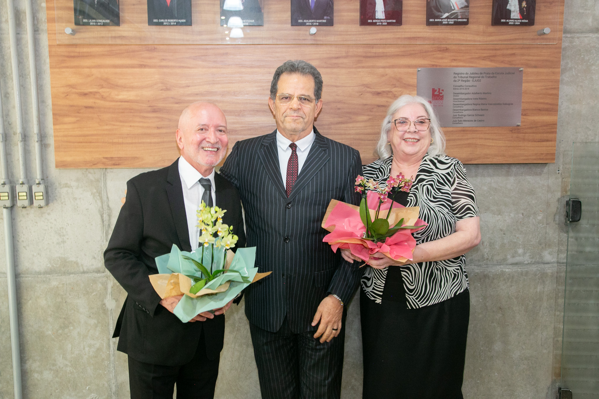 desembargador Alvaro Nôga, presidente Valdir Florindo e desembargadora Maria José Rebelo posam abaixo da galeria com os retratos dos diretores da Ejud