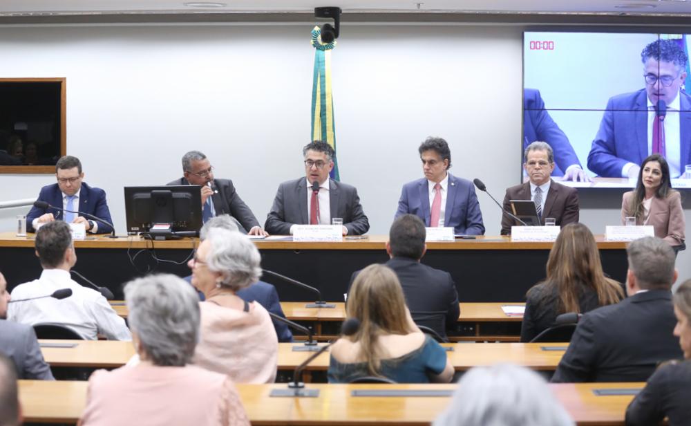 Vista da mesa de honra, com presidente Valdir, ministro Vieira de Mello Filho e outros(as) participantes, e das primeiras fileiras da plateia