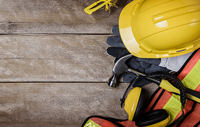 Imagem da notícia Imagem de capacete amarelo e equipamentos de segurança vistos de cima no canto direito da imagem