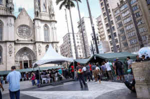 Imagem da Notícia Imagem da Praça da Sé com tendas de atendimento e pessoas