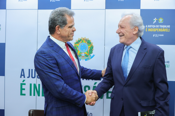 pres. Valdir Florindo cumprimenta o min. Ricardo Lewandovski à frente do painel com os logos "A Justiça do Trabalho é Indispensável"