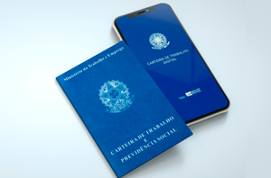 Ir para  Imagem da Notícia Carteira de trabalho física e um aparelho celular com imagem da CTPS digital, ambos em cima de uma superfície
