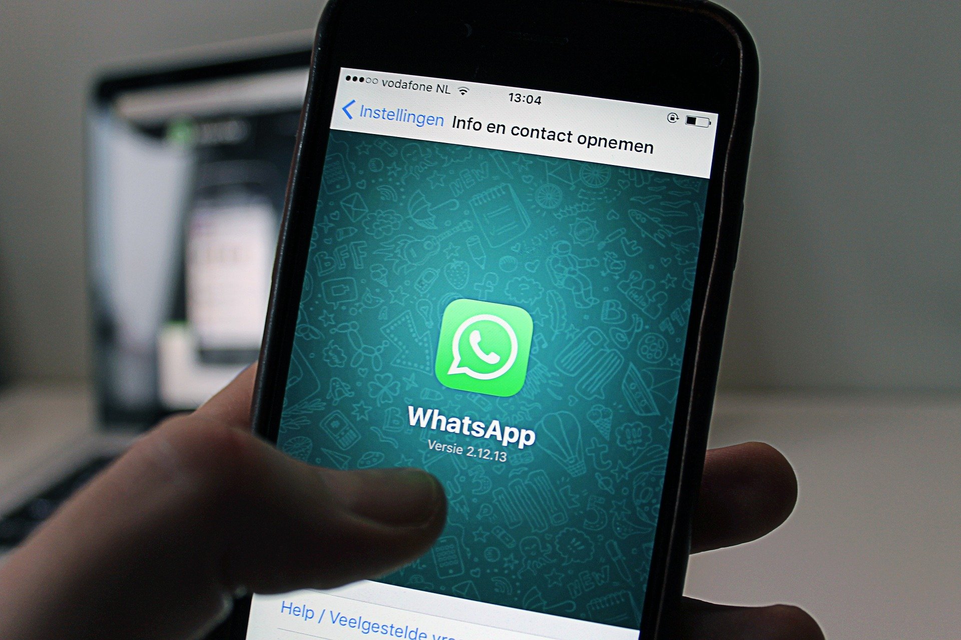 mão segurando celular exibindo a tela para
                    download do whatsapp
