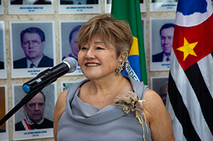 Imagem da Notícia Desembargadora de ascendência oriental fala ao microfone em evento oficial